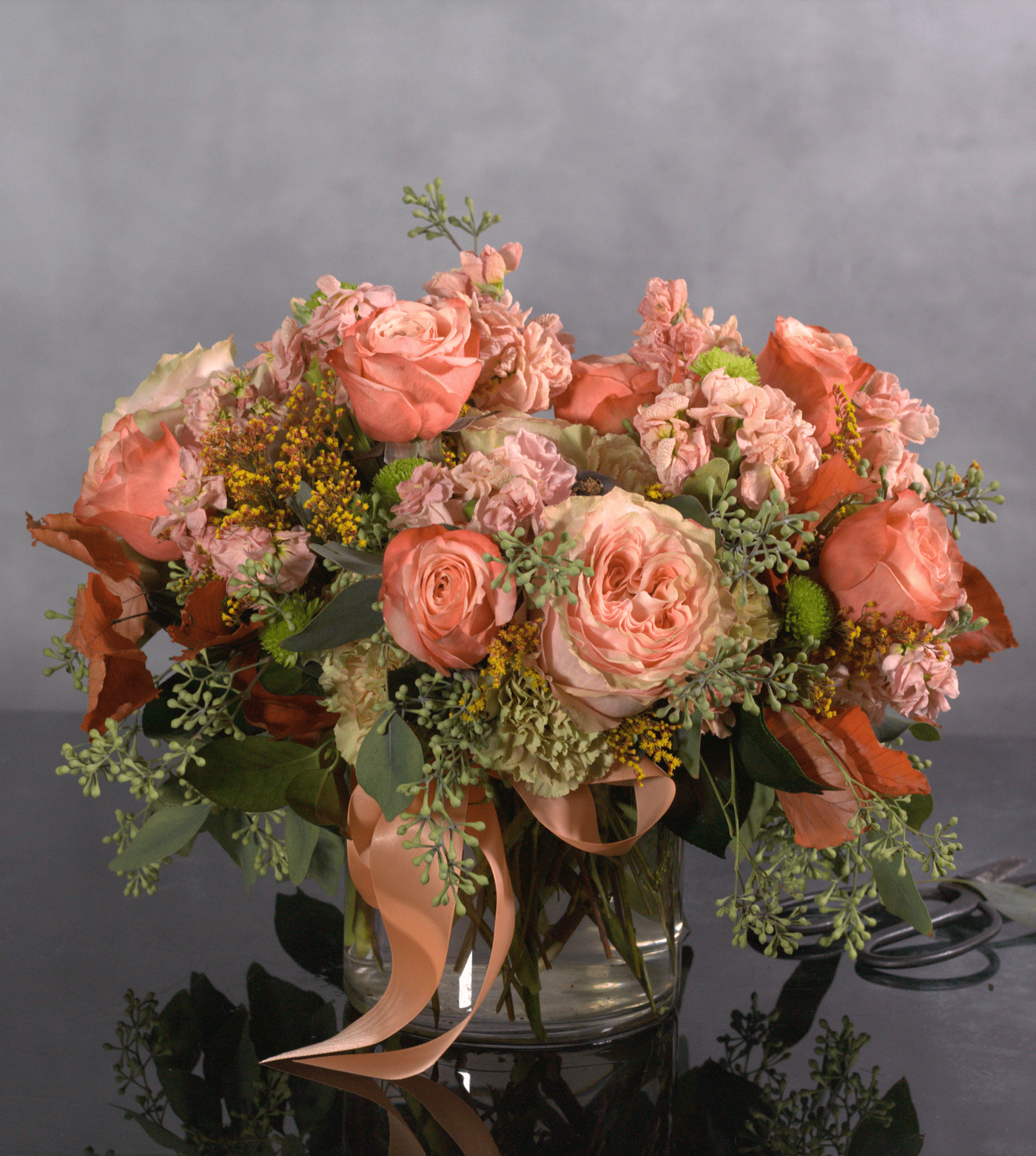 This exquisite arrangement captures the essence of fall romance, Santa Monica style. Delicate peach garden roses, symbolizing gratitude and appreciation, are artfully paired with airy seeded eucalyptus, creating a sense of effortless beauty. Perfect for any special occasion or a luxurious touch to your home.