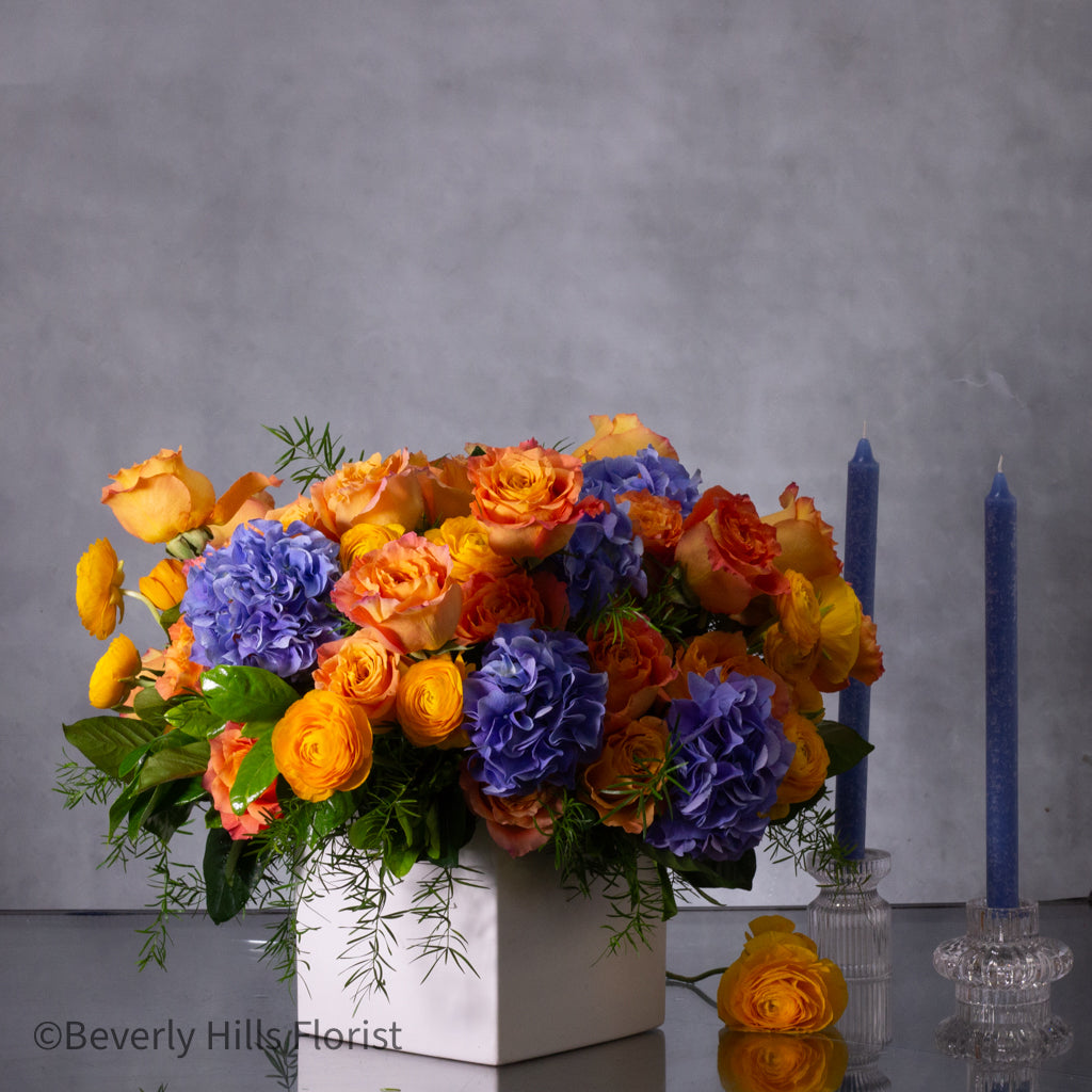 The Tale of Orange Roses and Blue Hydrangeas Arrangement
Luxury Orange Garden Roses and Blue Hydrangeas in White Vase
Sunburst Floral Arrangement for Same-Day Delivery Santa Monica
Vibrant Orange and Blue Floral Arrangement Los Angeles Delivery