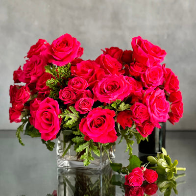 A Moment In Time arrangement with hot pink Ecuadorian roses and scented geraniums in a modern design, available for same-day delivery by Santa Monica Florist.