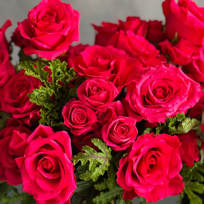 A Moment In Time arrangement with hot pink Ecuadorian roses and scented geraniums in a modern design, available for same-day delivery by Santa Monica Florist.