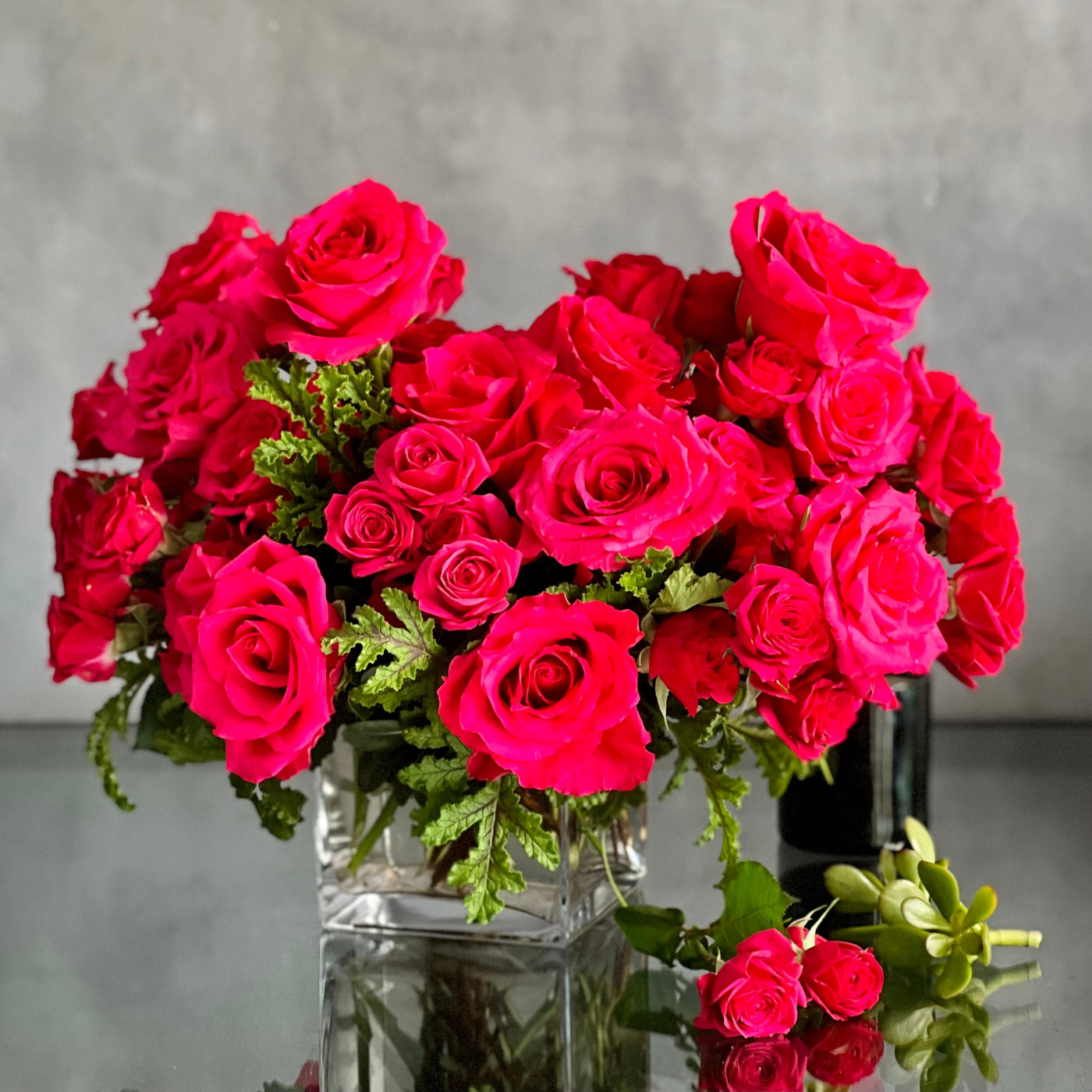 A Moment In Time arrangement with hot pink Ecuadorian roses and scented geraniums in a modern design, available for same-day delivery by Santa Monica Florist.