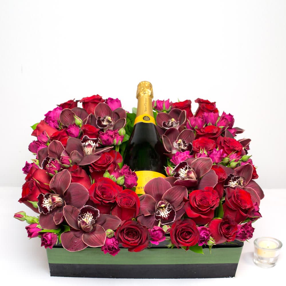 A Toast To You! arrangement with red and pink roses, burgundy orchids, and a bottle of wine in a square box, same-day delivery by Santa Monica Florist.