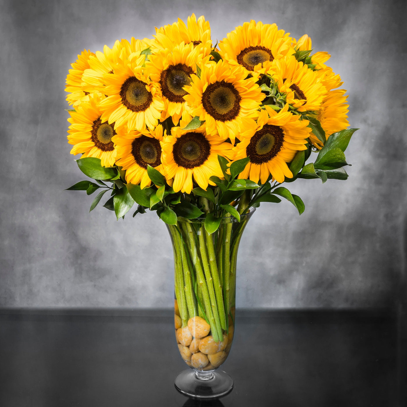 Baby It's Sunny Outside arrangement with tall sunflowers in a vase with pebbles, available for same-day delivery by Santa Monica Florist.