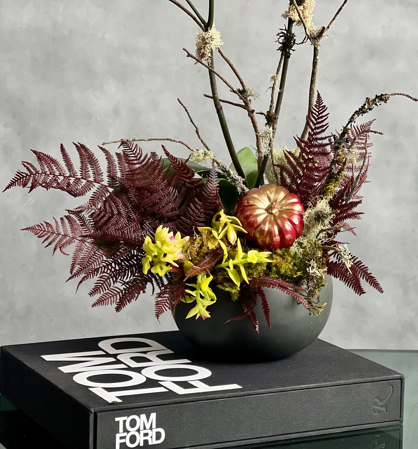 Beautiful as Always double yellow orchids with fall accents in a modern matte black ceramic bowl, available for same-day delivery by Santa Monica Florist.