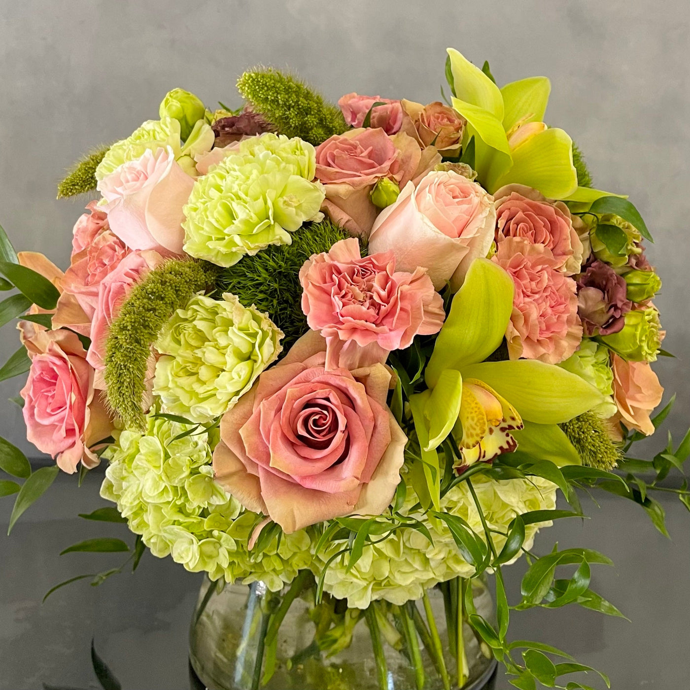 Beautiful Garden arrangement with pink roses, green and peach orchids, hydrangeas, and dianthus in a 6x6 cylinder vase, available for same-day delivery by Santa Monica Florist.