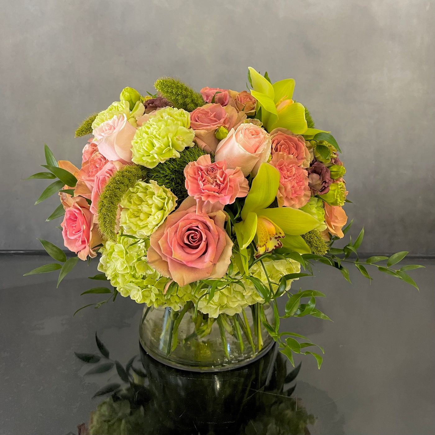 Beautiful Garden arrangement with pink roses, green and peach orchids, hydrangeas, and dianthus in a 6x6 cylinder vase, available for same-day delivery by Santa Monica Florist.