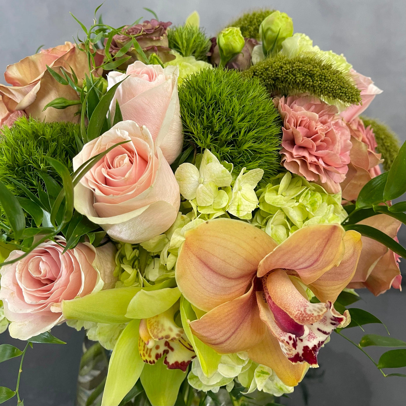 Beautiful Garden arrangement with pink roses, green and peach orchids, hydrangeas, and dianthus in a 6x6 cylinder vase, available for same-day delivery by Santa Monica Florist.