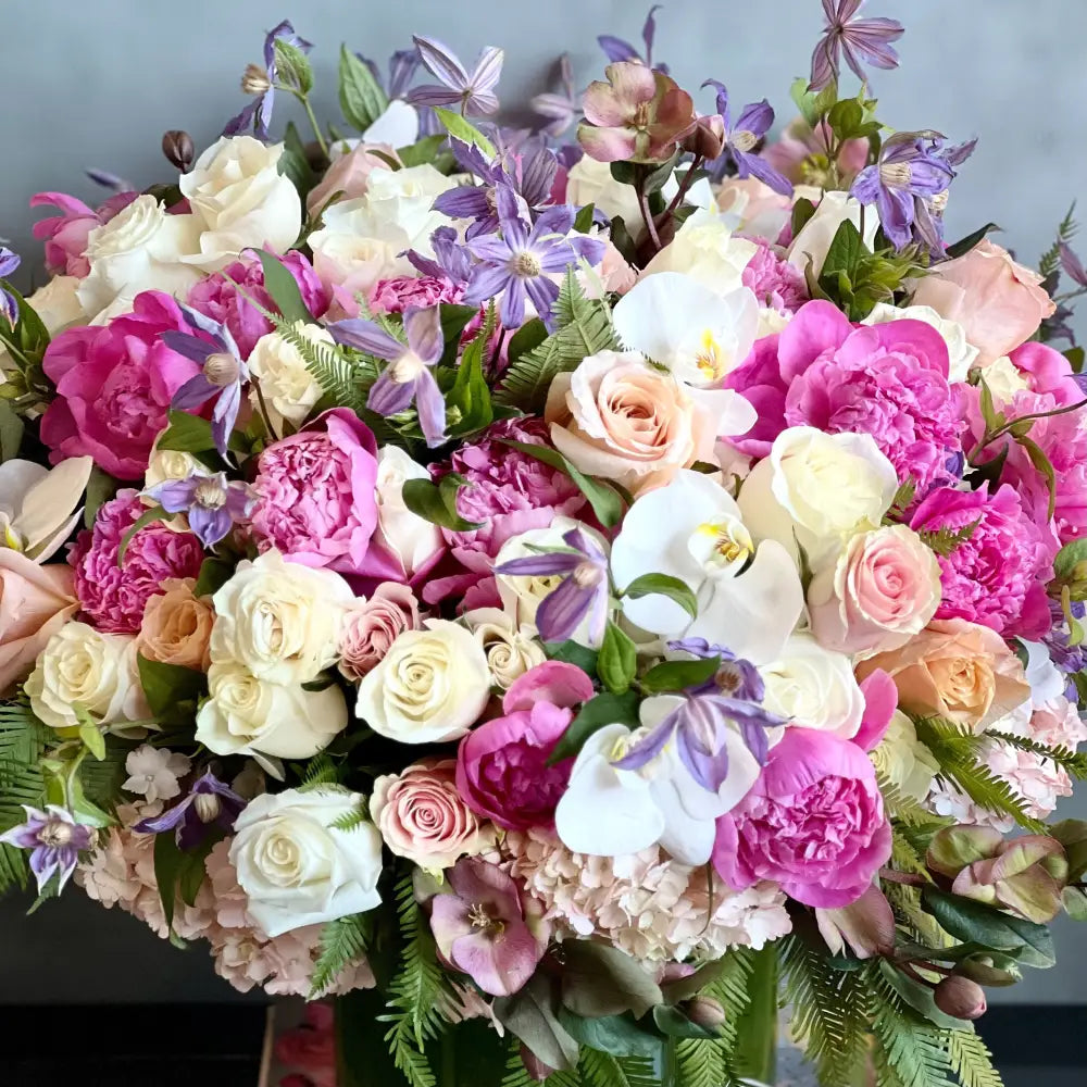 Blooming arrangement with peonies, roses, orchids, hydrangeas, and seasonal greens in a chic design, available for same-day delivery by LA Orchidia.