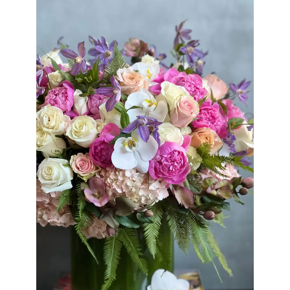 Blooming arrangement with peonies, roses, orchids, hydrangeas, and seasonal greens in a chic design, available for same-day delivery by LA Orchidia.