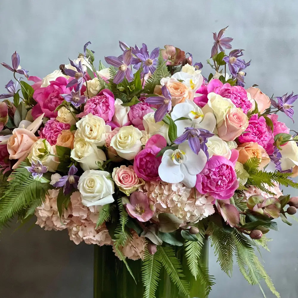 Blooming arrangement with peonies, roses, orchids, hydrangeas, and seasonal greens in a chic design, available for same-day delivery by LA Orchidia.