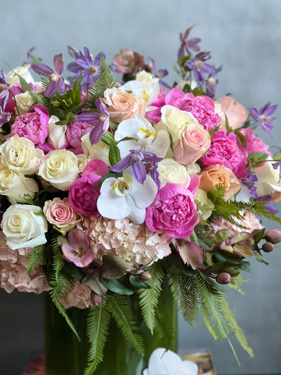 Blooming arrangement with peonies, roses, orchids, hydrangeas, and seasonal greens in a chic design, available for same-day delivery by Santa Monica Florist.