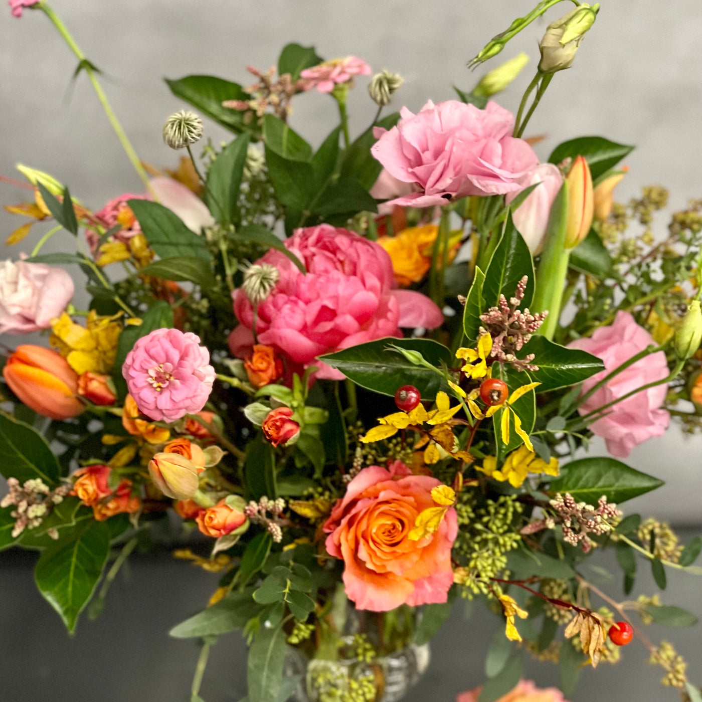 Blossoms Of The Roaring Twenties arrangement with orange garden roses, coral peonies in a vintage 20's era vase, available for same-day delivery by Santa Monica Florist.