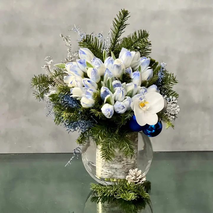 Blue Holiday arrangement with snow-tinted tulips and an orchid in a glass vase, available for same-day delivery by LA Orchidia.