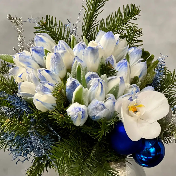 Blue Holiday arrangement with snow-tinted tulips and an orchid in a glass vase, available for same-day delivery by LA Orchidia.