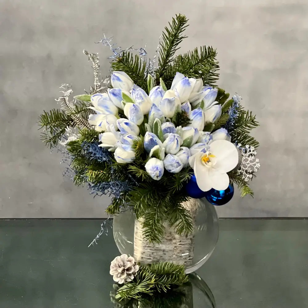 Blue Holiday arrangement with snow-tinted tulips and an orchid in a glass vase, available for same-day delivery by LA Orchidia.
