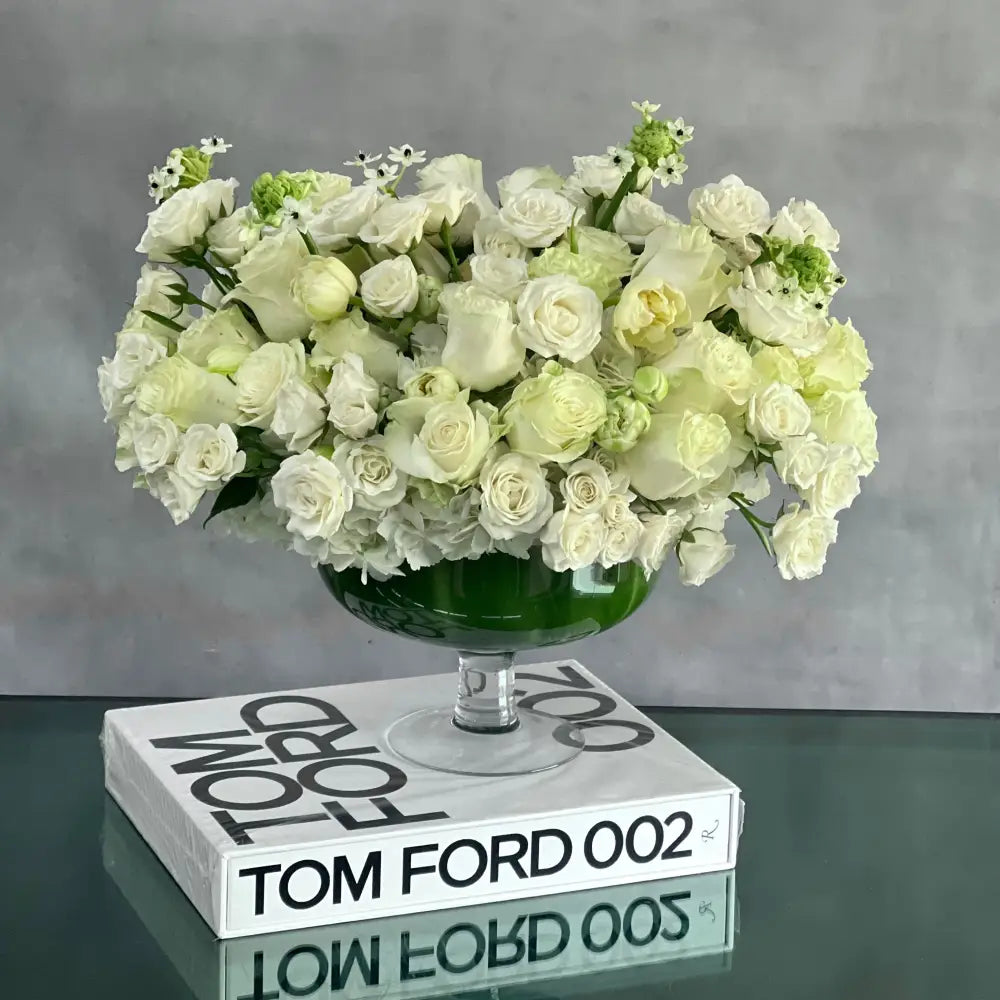 Capture The Heart arrangement with white roses and seasonal flowers in a pedestal vase.