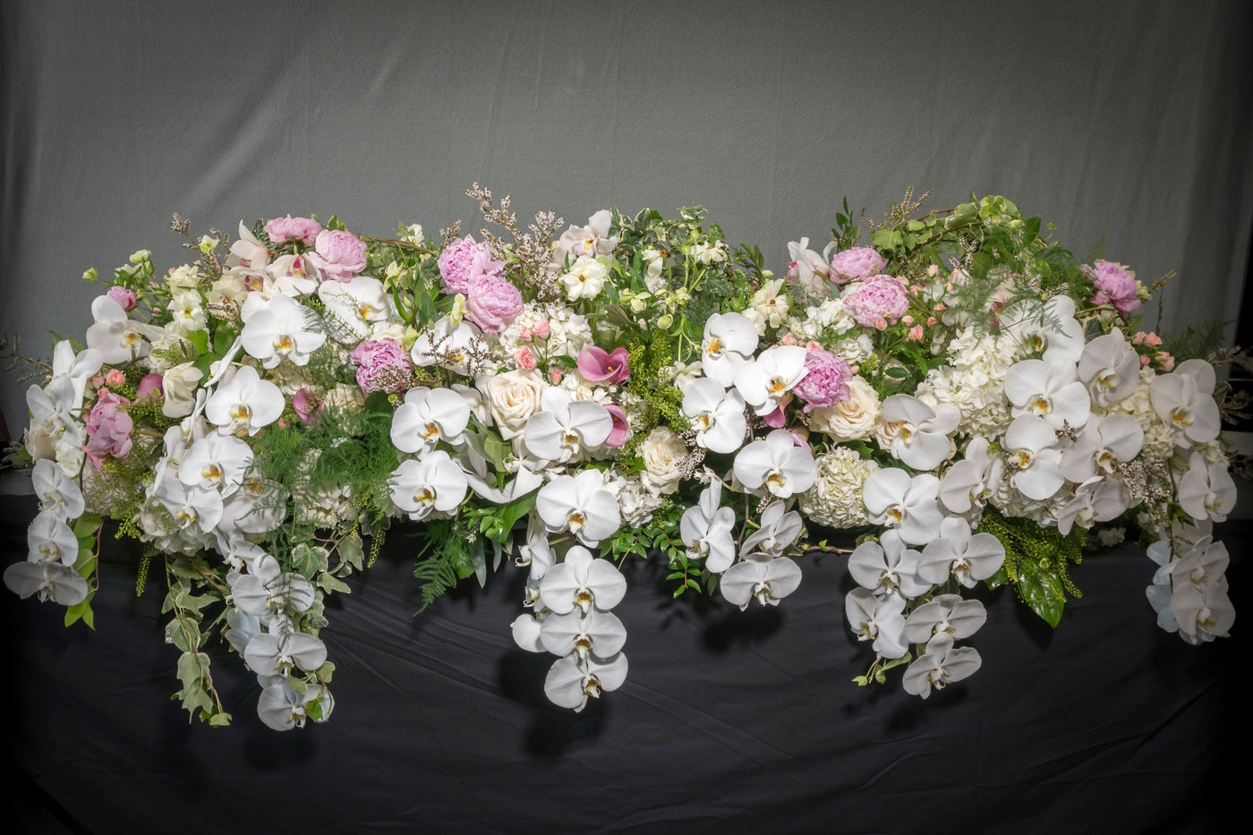 Casket Floral arrangement with peonies, garden roses, orchids, and white blooms, designed for funeral services, available for same-day delivery by Santa Monica Florist.