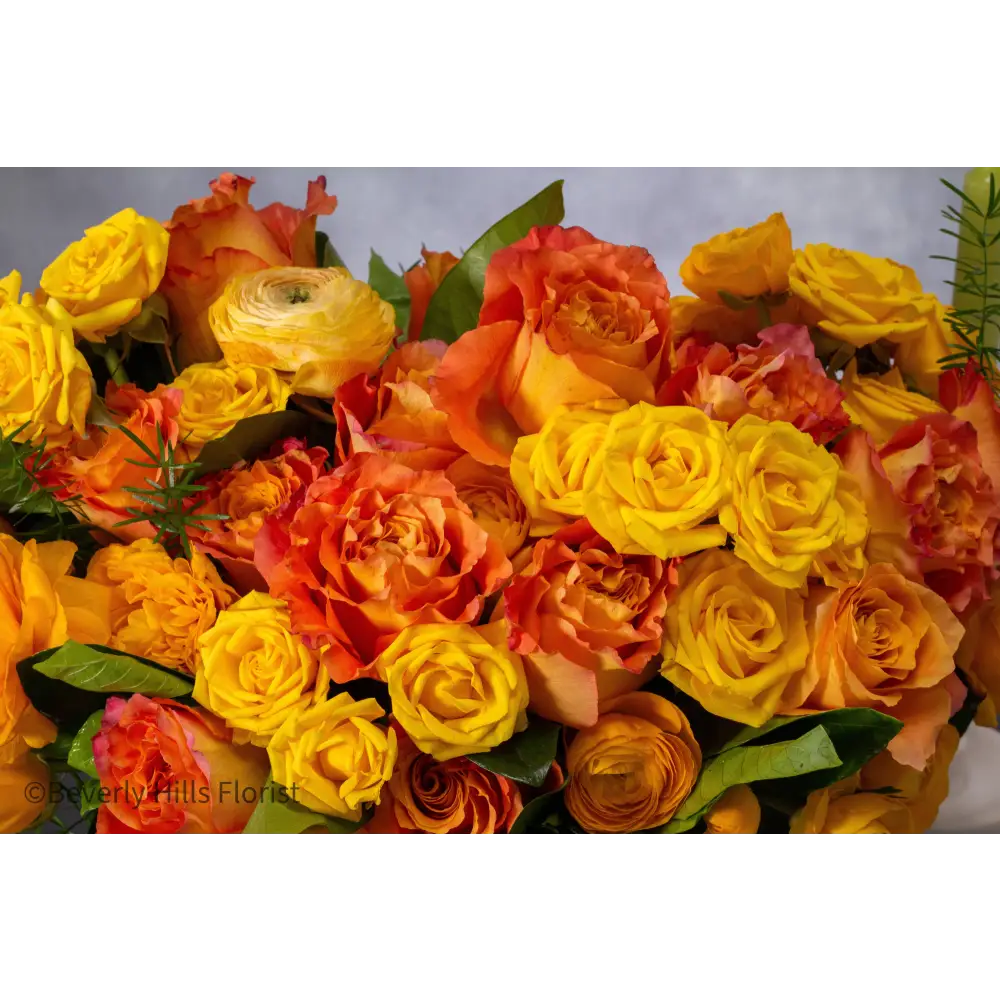 Compact floral arrangement with orange peel-colored blooms in a white ceramic vase, perfect for same-day delivery.