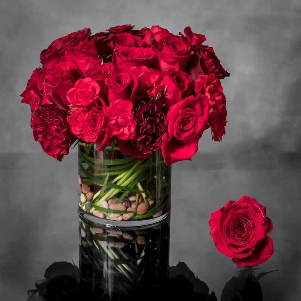 LA Orchidia presents Crimson Reds for same day delivery! Includes Red Roses, Seasonal Greens and are accented with stones in a glass vase. Perfect for Love and Romance, Birthdays, Holiday and more!