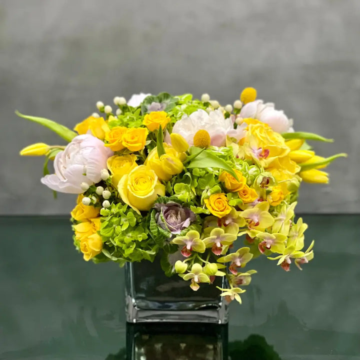 LA Orchidia presents Mellow Yellow for same day delivery! Includes, Yellow Roses, White and light pink Peonies, Green Hydrangeas, Baby  Orchids, cabbage, yellow Tulips and seasonal berries 
