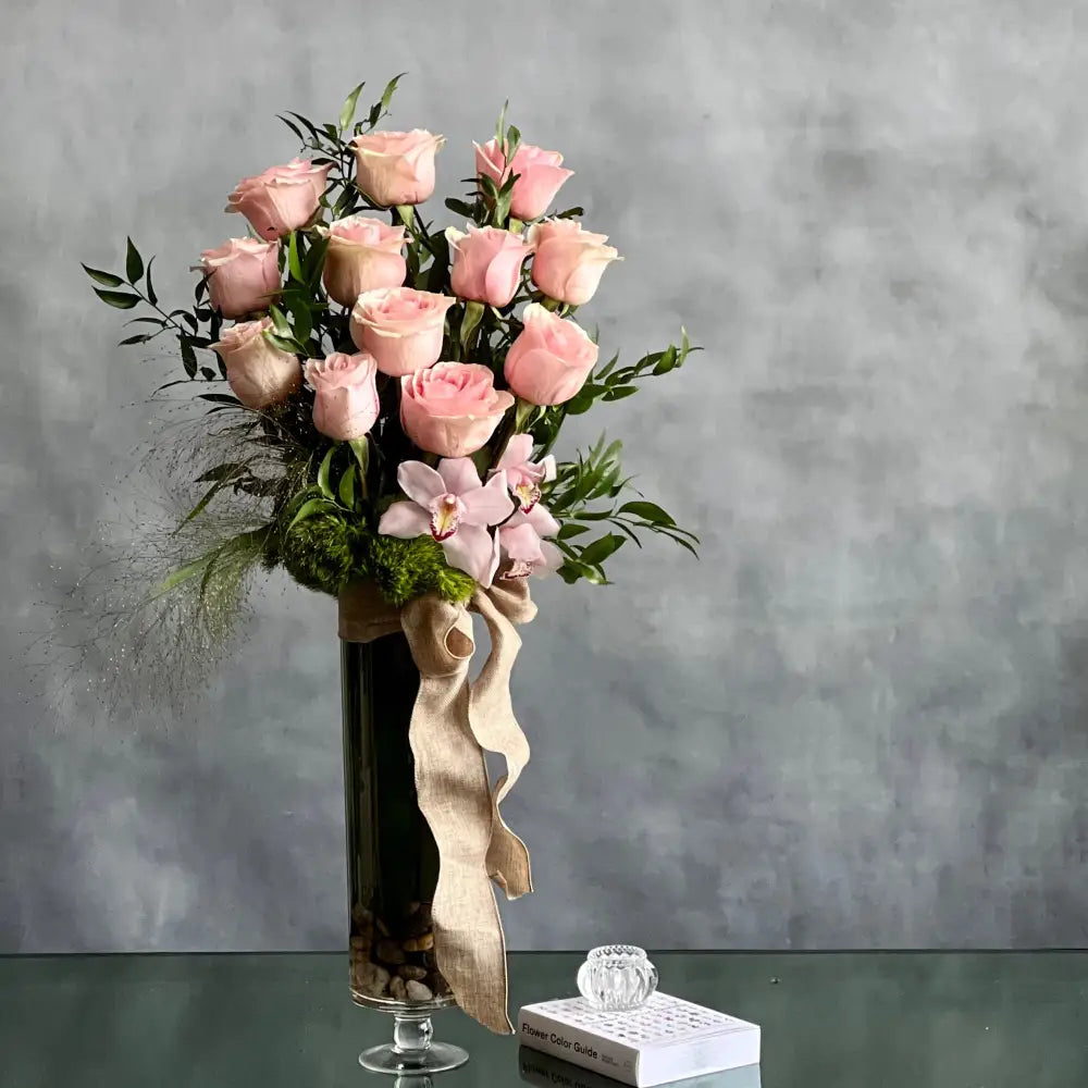 12 Pink Long Stem Roses Standing Tall arrangement with Ecuadorian long-stem roses and cymbidium orchids in a glass vase, available for same-day delivery by LA Orchidia.