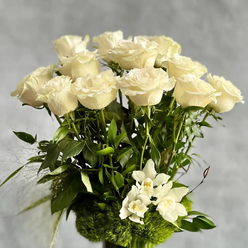 12 White Long Stem Roses Standing Tall arrangement with Ecuadorian long-stem roses and cymbidium orchids in a glass vase, available for same-day delivery by LA Orchidia.