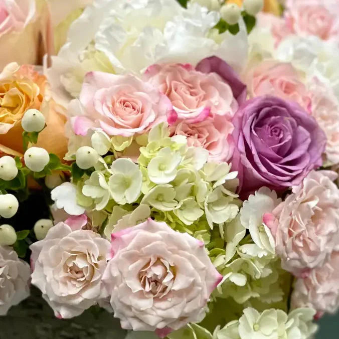 Pastel Perfection floral arrangement with soft pastel roses, Dutch hydrangeas, and seasonal flowers in a box base tied with a cream bow, available for same-day delivery