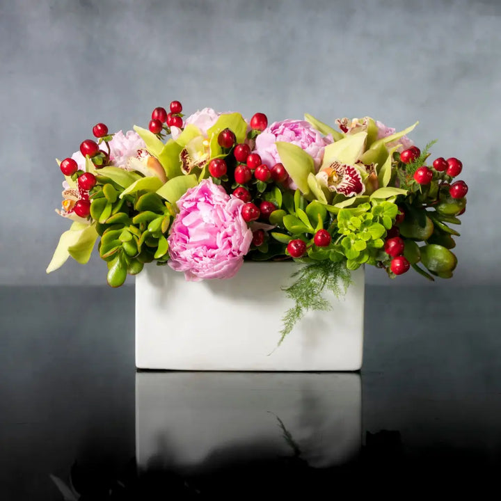 LA Orchidia presents a beautiful arrangement for same day delivery. In this piece we have pink Peonies, Berries and Seasonal greens accented with green Cymbidium Orchids. Made for a birthday, office decor or a welcome home. 