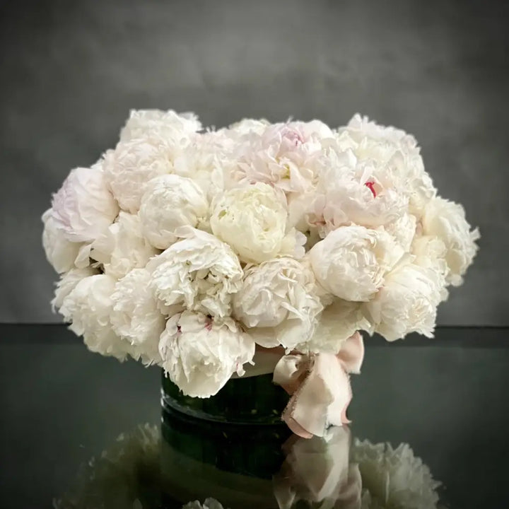Peony Wonder presented by LA Orchidia can also be made for same day delivery ! This over 50 white blush peony arrangement nested in a simple glass vase with a bow. Its beautiful in itself without any other floral. A beautiful sentiment for Birthdays, Welcome Homes, Thank you, Thinking of you and sympathies. 