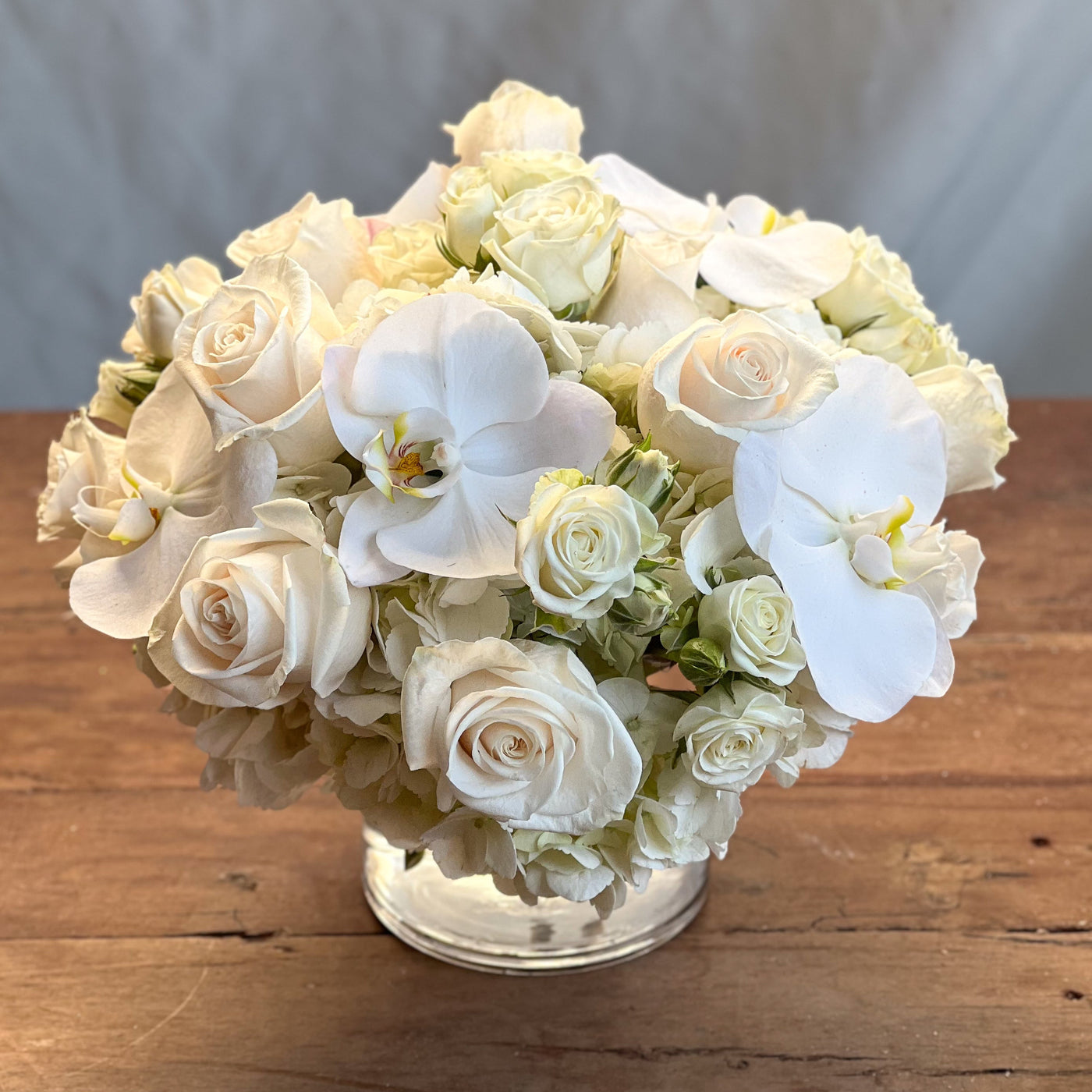 Elegant white roses and orchids arrangement in a glass vase, Santa Monica Florist.