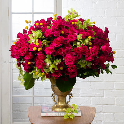 Amore Roses arrangement with red, pink, and cream roses, orchids, and spray roses in a golden pedestal container, available for same-day delivery by Santa Monica Florist.